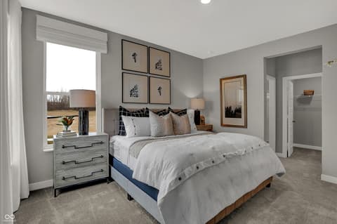 Primary bedroom at 19805 Hazelnut Boulevard, Noblesville, IN — Bright primary bedroom with ensuite and gallery wall.