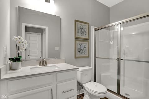 Primary bathroom at 19805 Hazelnut Boulevard, Noblesville, IN — Spa-like primary bath with marble counters and glass shower