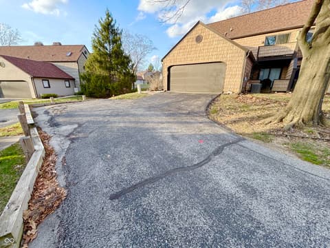 Front exterior at 9728 Revere Way, Indianapolis, IN — Spacious driveway with two-car garage in quiet neighborhood.