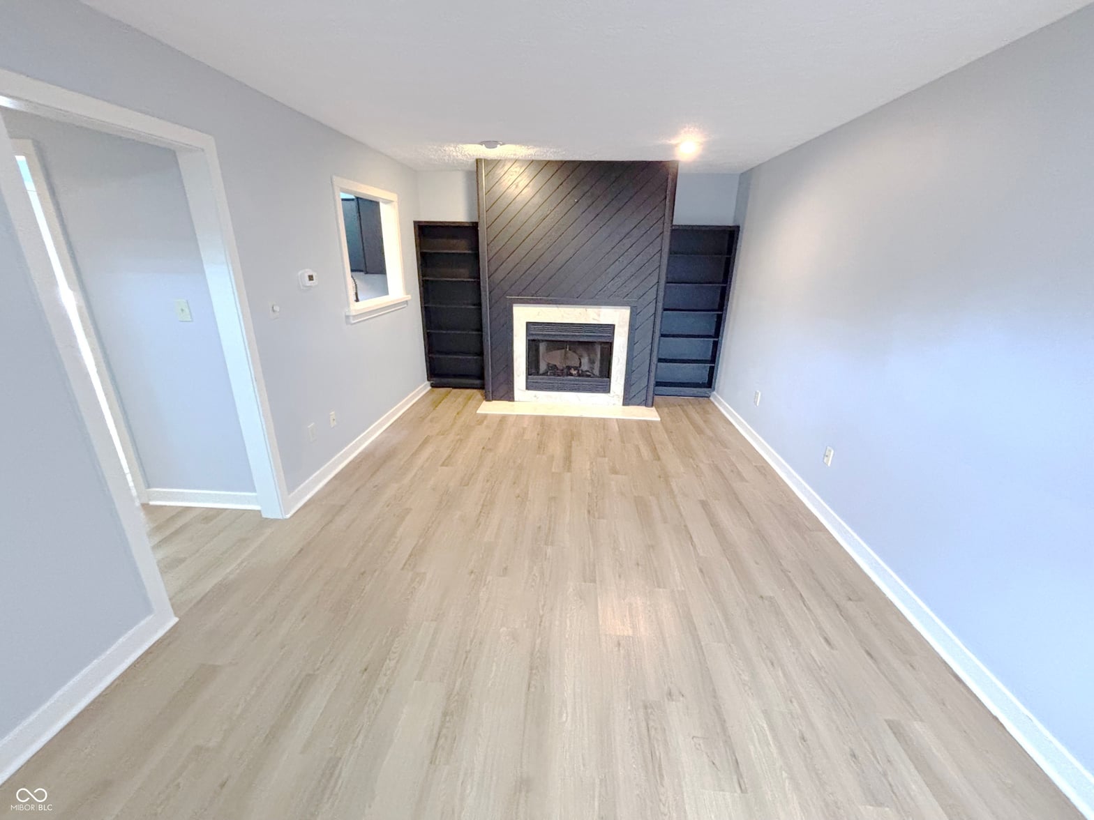 Family room at 9728 Revere Way, Indianapolis, IN — Modern fireplace focal point with built-in shelving.