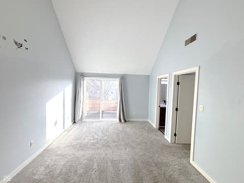 Bedroom at 9728 Revere Way, Indianapolis, IN — Bright bedroom with vaulted ceilings and deck access.