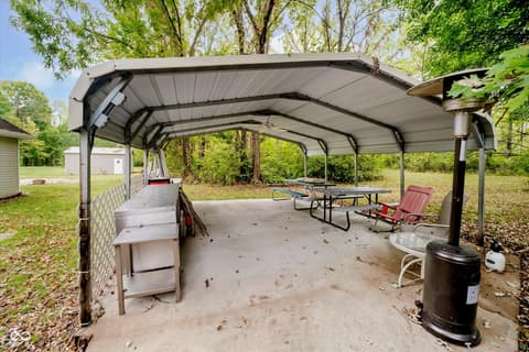 Outdoor living area at 9135 E 256th Street, Arcadia, IN — Covered outdoor entertaining space with fire pit and grill.