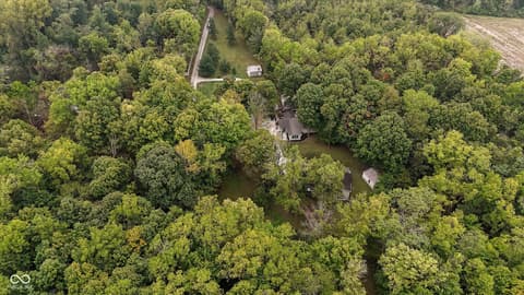 Aerial view at 9135 E 256th Street, Arcadia, IN — Secluded wooded property with creek access and privacy.