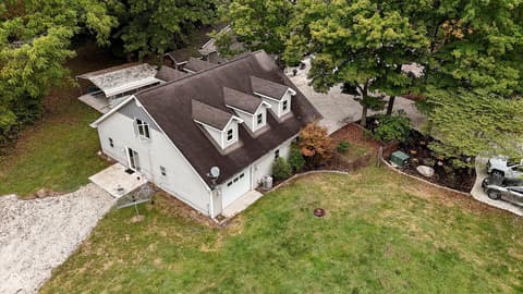 Aerial view at 9135 E 256th Street, Arcadia, IN — Modern home nestled in wooded lot with mature landscaping.