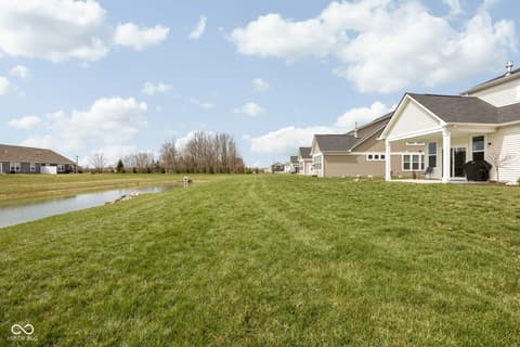 Backyard at 887 Tuxedo Drive, Westfield, IN — Spacious level yard with pond in newer suburban community.