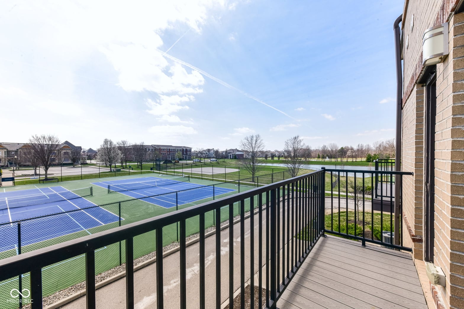 Private balcony overlooking pristine tennis courts and community grounds.