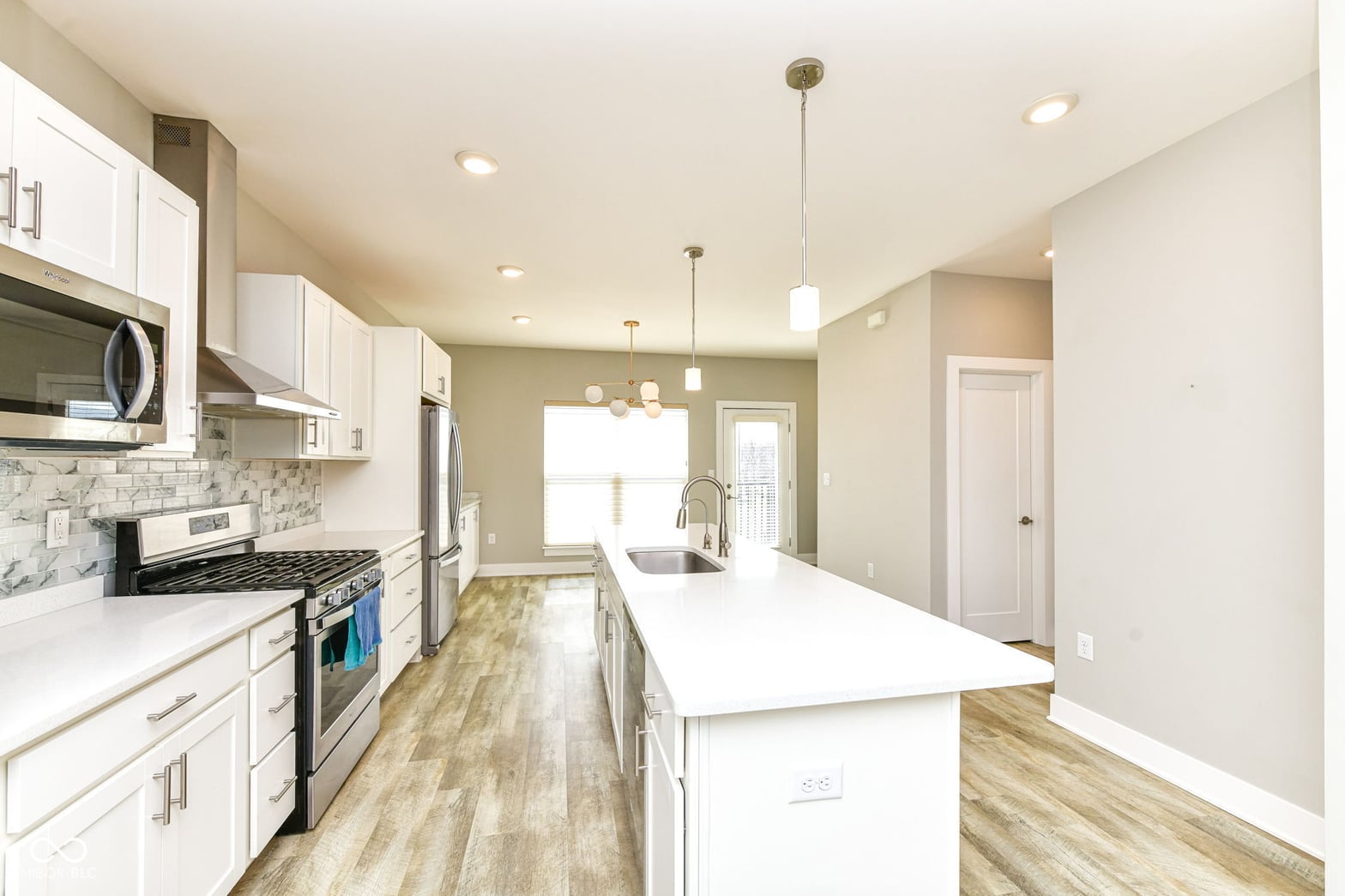 Modern renovated kitchen with island and stainless appliances.
