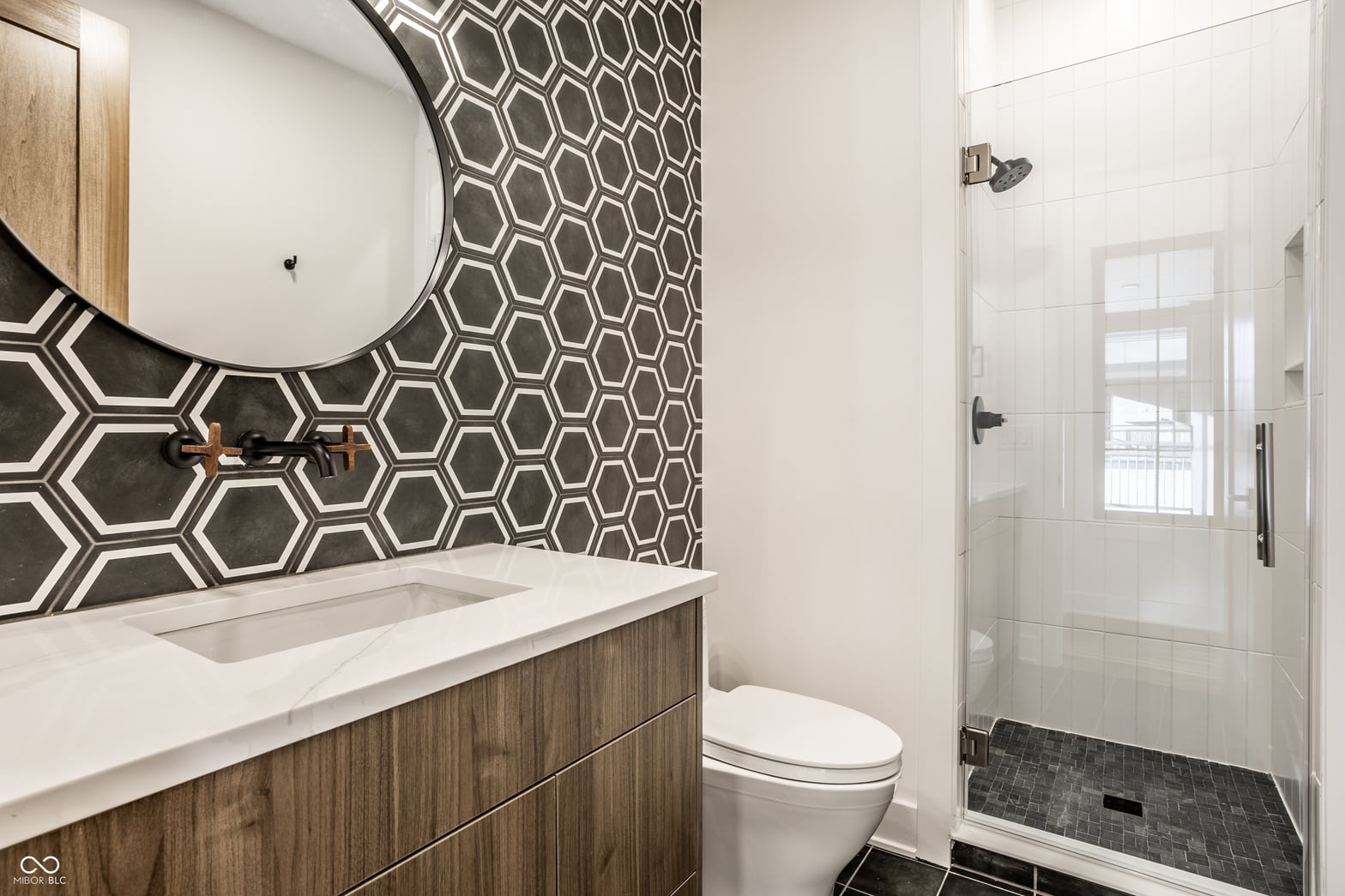 Stunning modern primary bath with geometric tile accent.