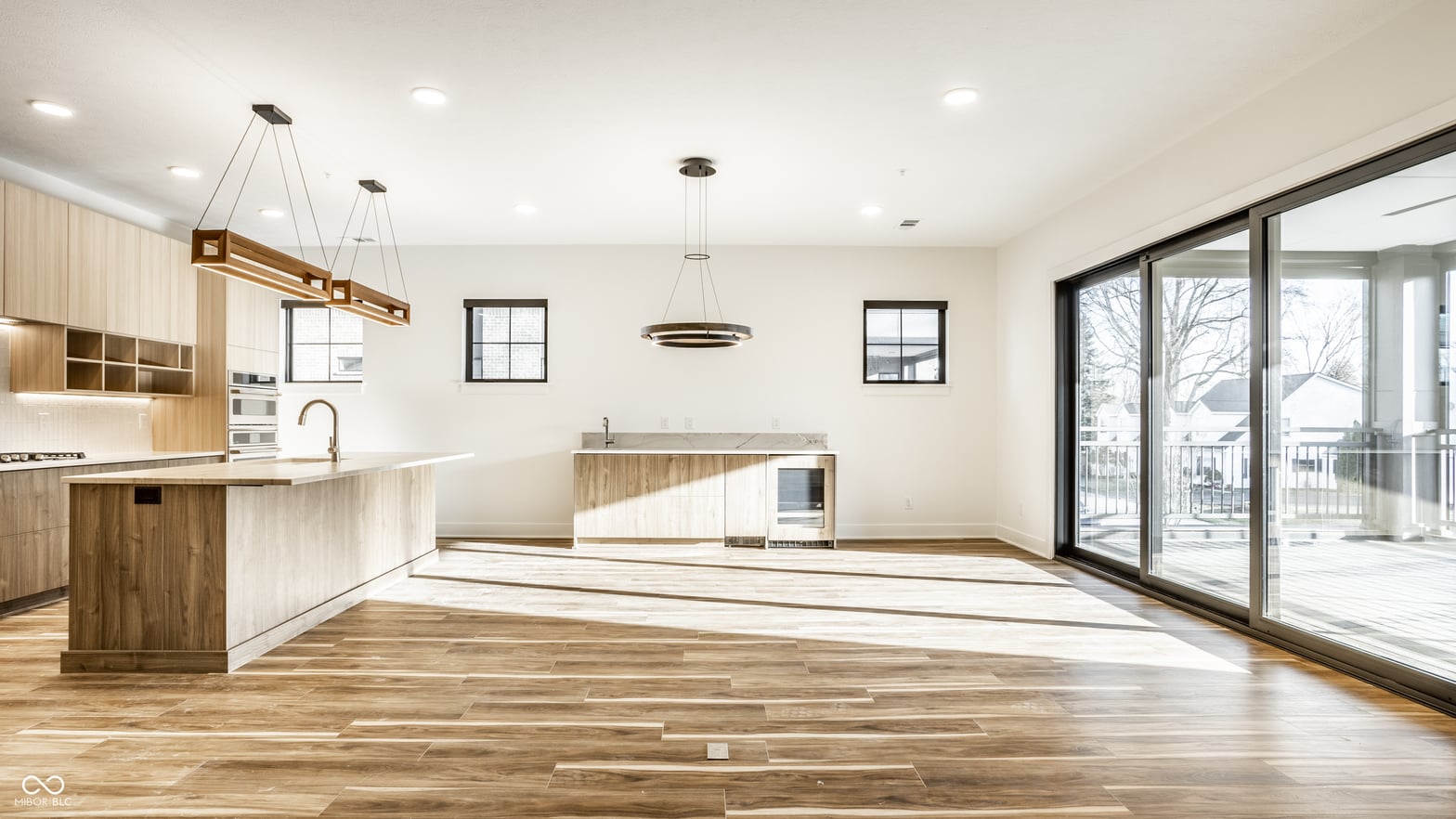Bright contemporary kitchen with hardwood floors and deck access.