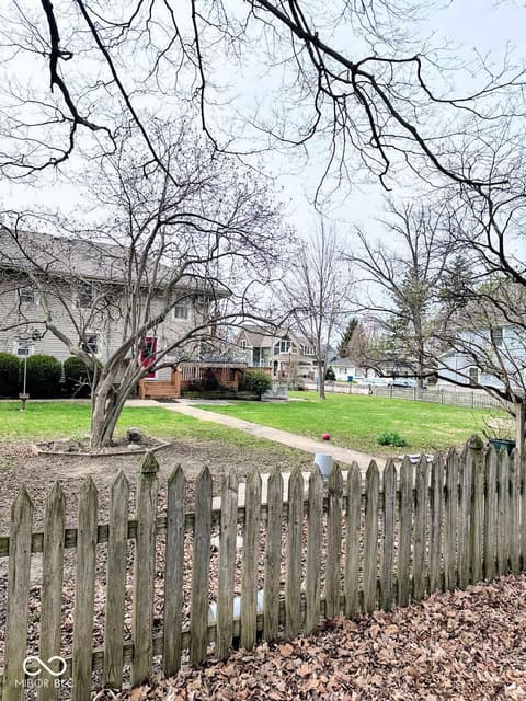 Front exterior at 310 2nd Street NE, Carmel, IN — Charming neighborhood with mature trees and picket fencing.