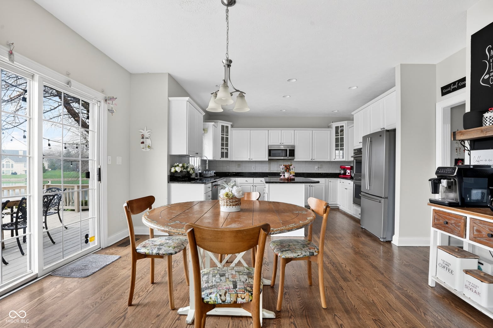 Bright updated kitchen with black granite and white cabinetry.