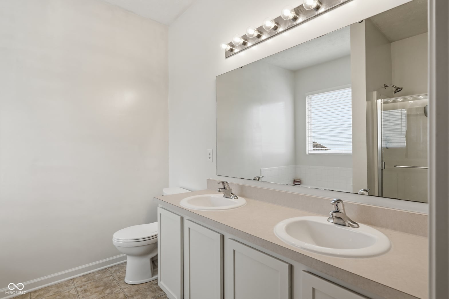 Spacious primary bath with dual vanity and modern finishes.
