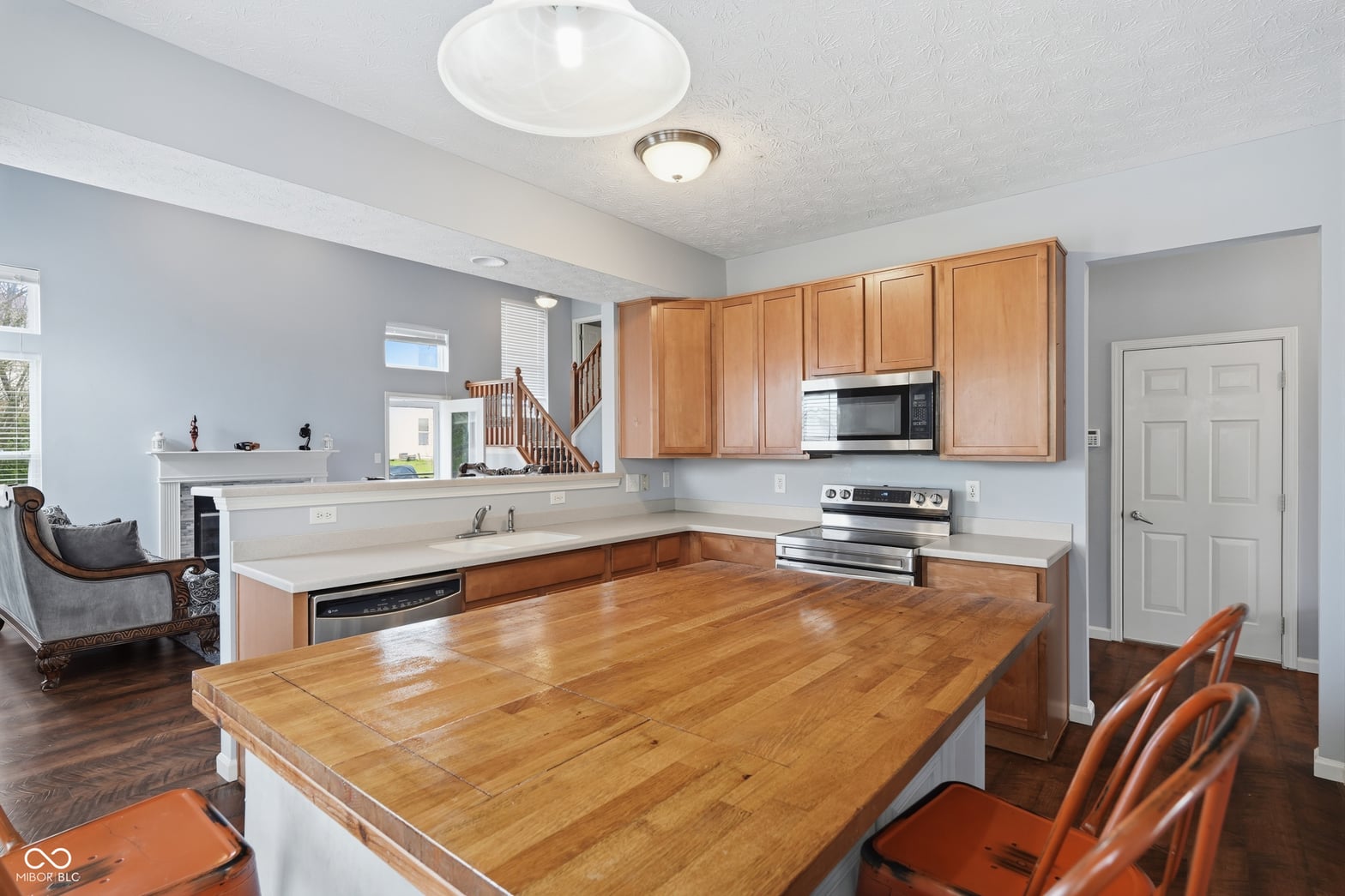 Spacious kitchen with wood island and stainless appliances.