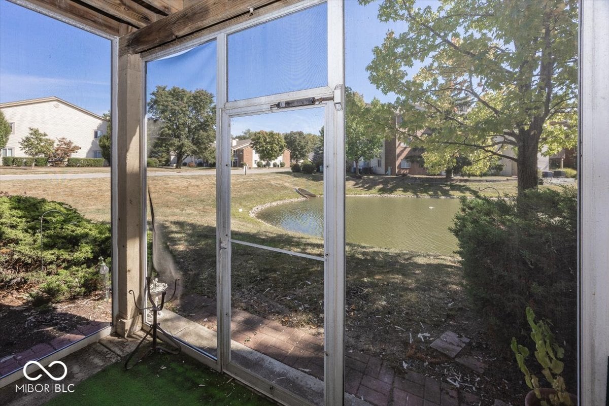 Screened porch overlooks peaceful pond and mature trees.