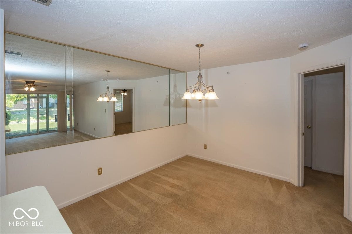 Bright dining area with kitchen pass-through and pendant lighting.