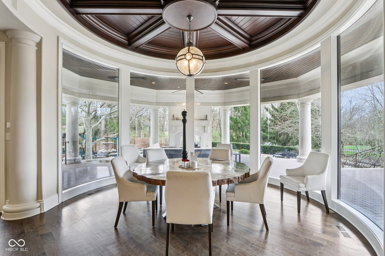 Stunning circular dining room with panoramic windows and coffered ceiling.
