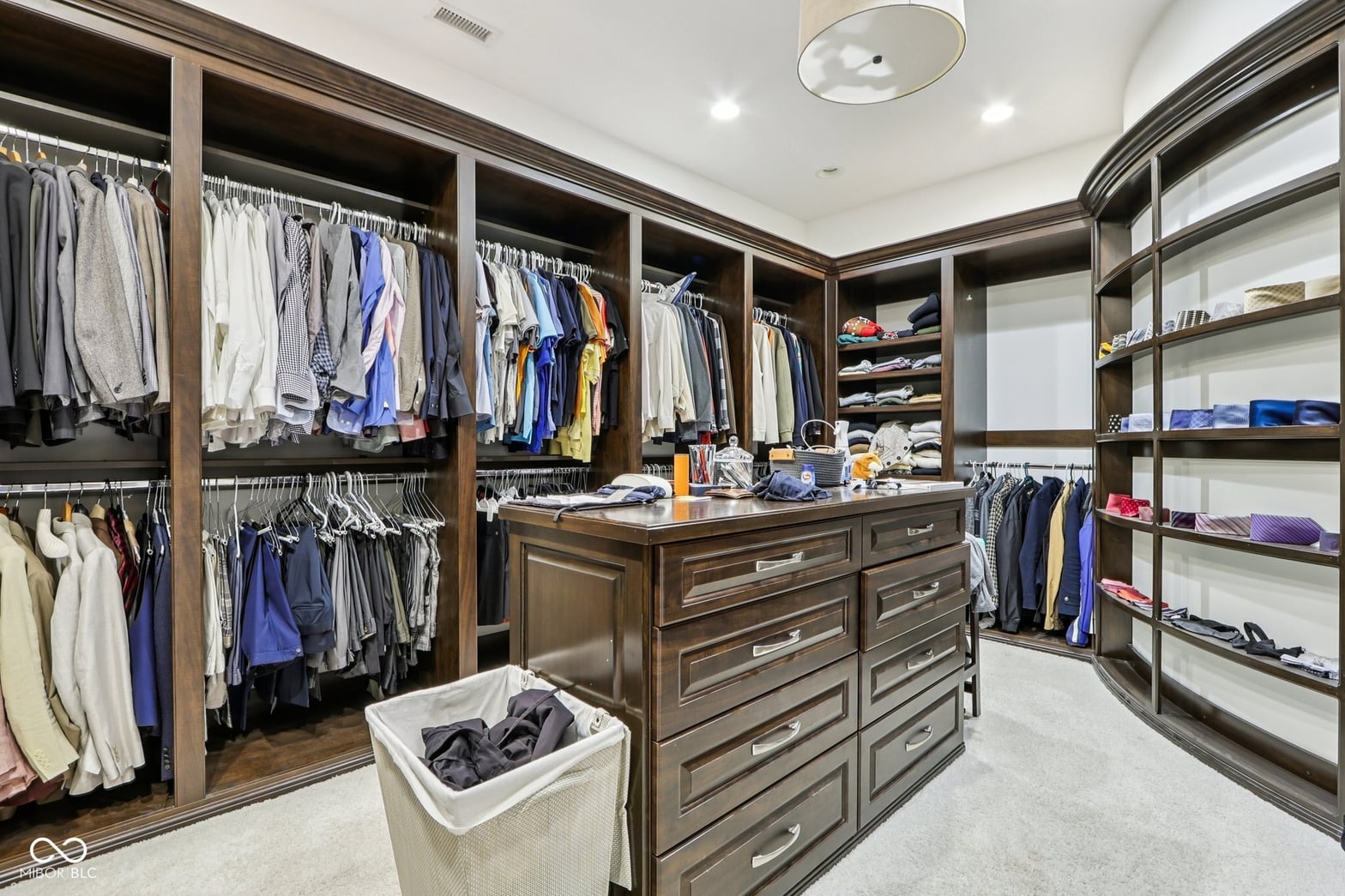 Luxurious primary closet with custom island and organized storage.