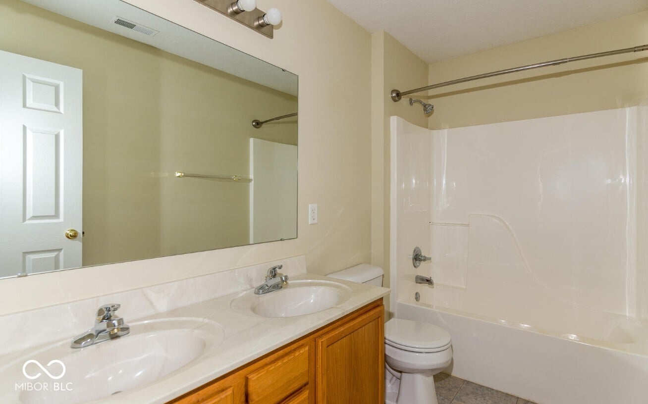 Spacious primary bath with double vanity and granite counters.