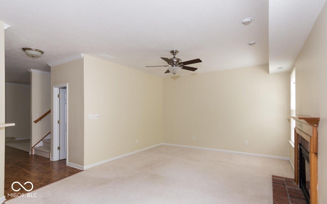 Spacious family room with fireplace and ceiling fan.
