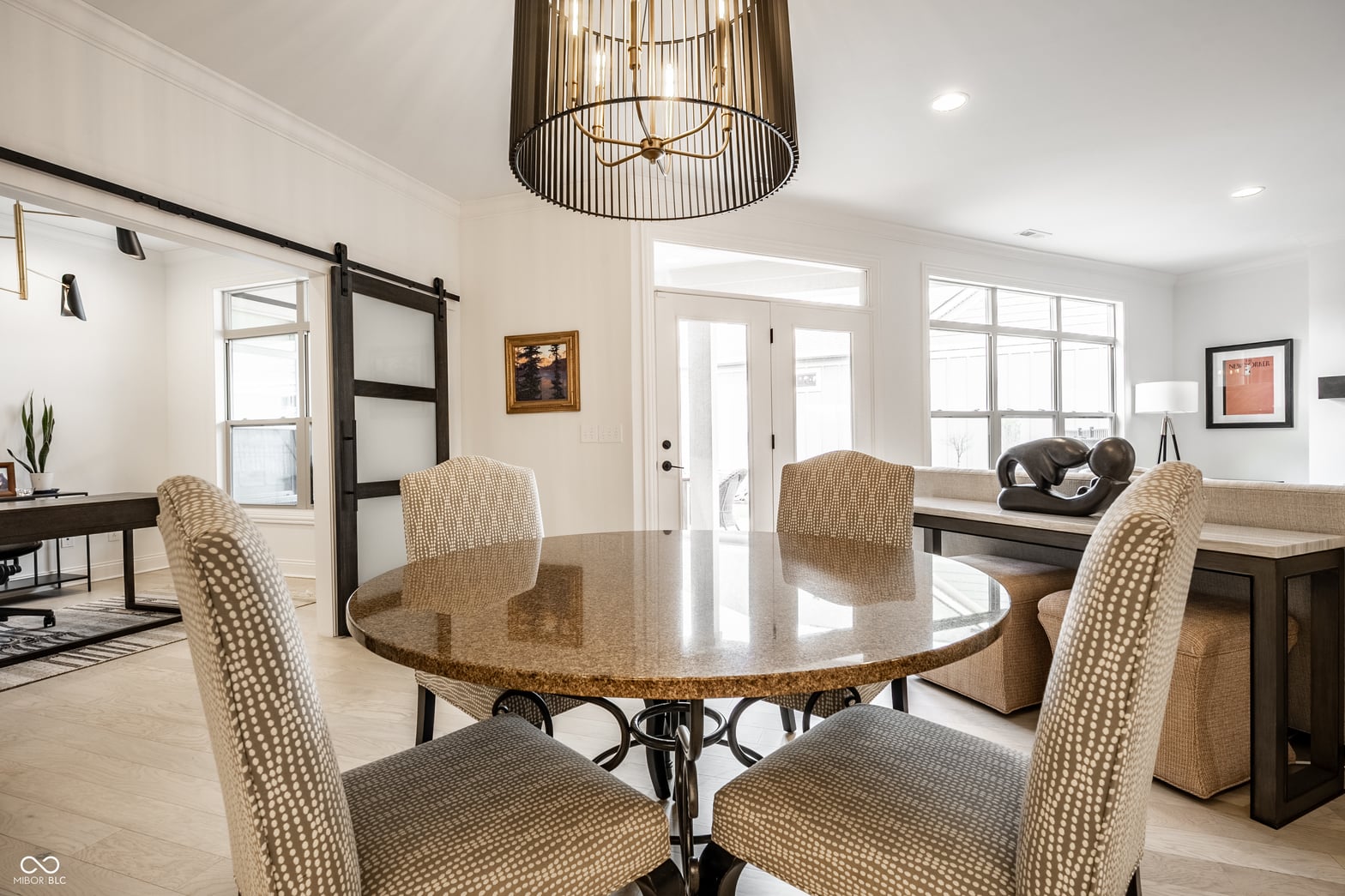 Bright open concept dining with granite table and modern fixtures.