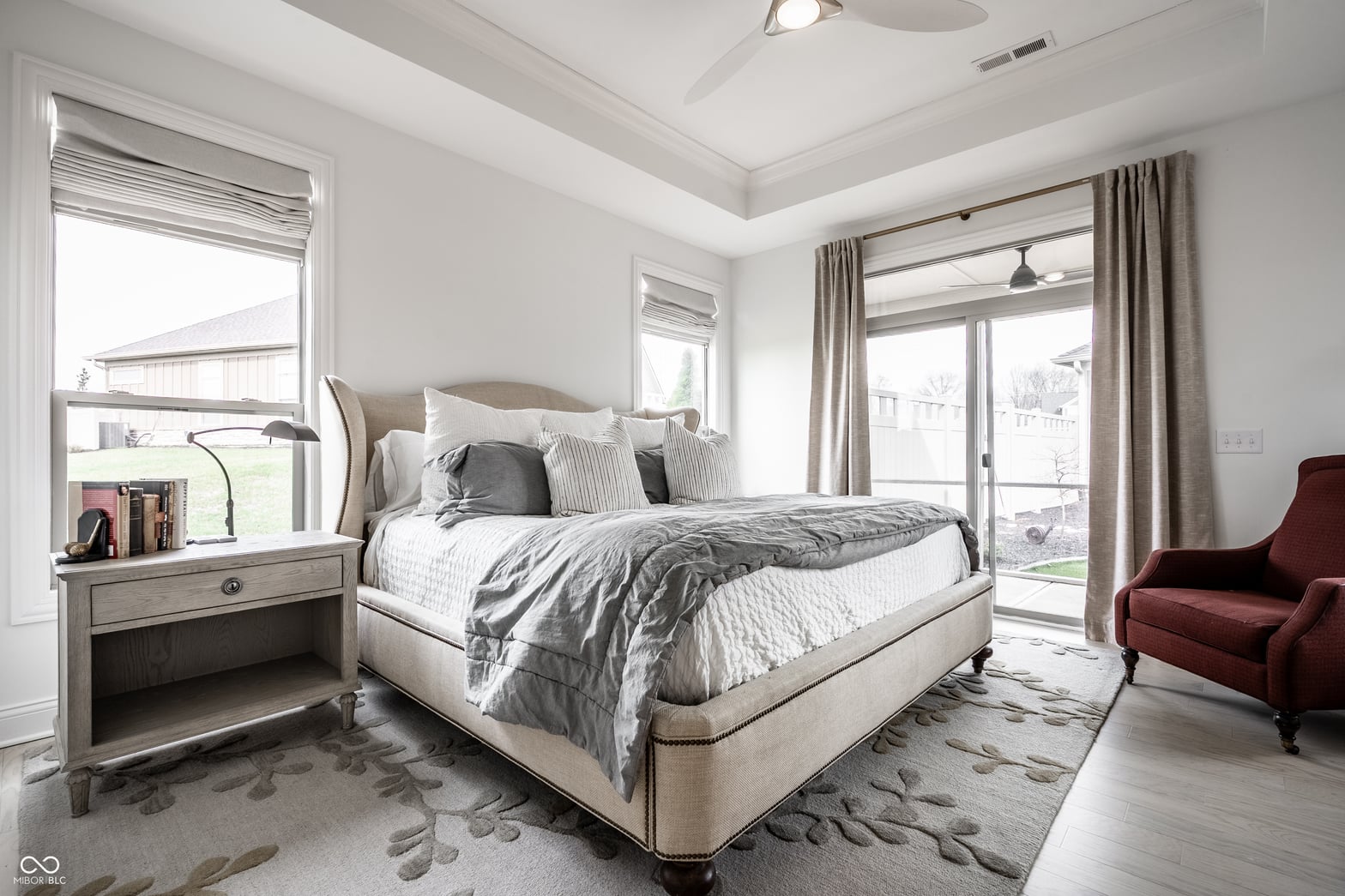 Bright primary bedroom with coffered ceiling and patio access.