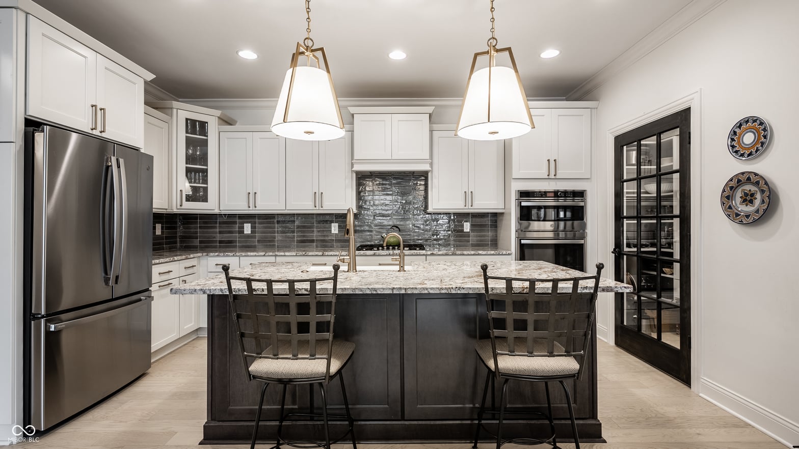 Modern kitchen with granite island and premium stainless appliances.