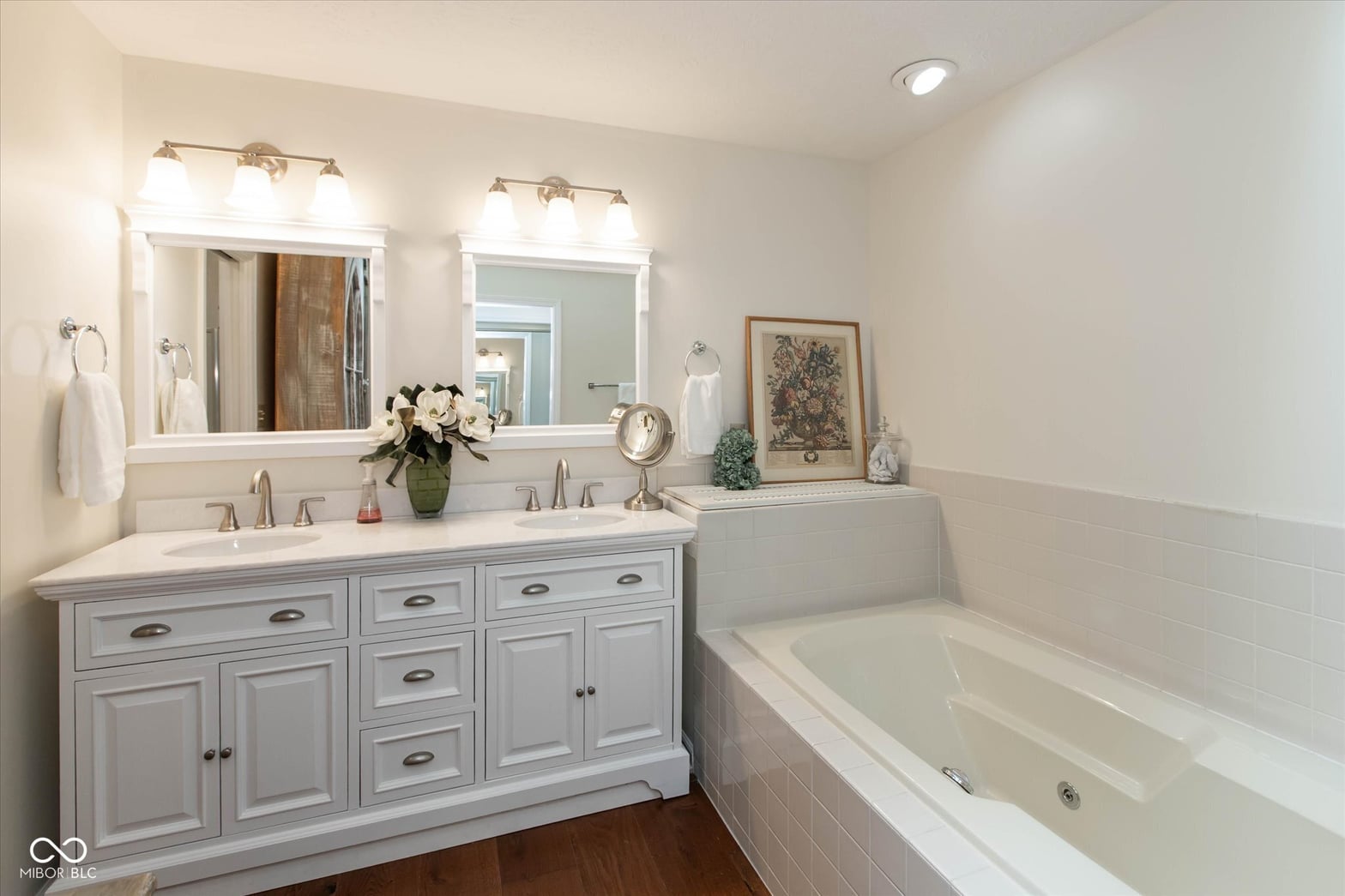 Elegant primary bath with double vanity and soaking tub.