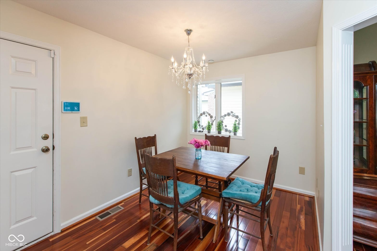 Bright dining room with hardwood floors and chandelier.