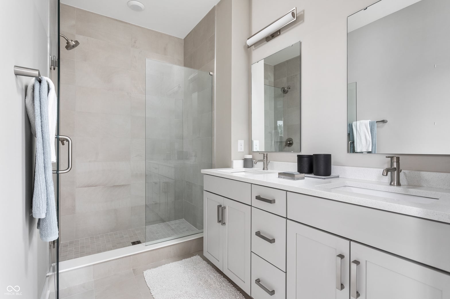Luxurious primary bath with dual vanity and frameless shower.