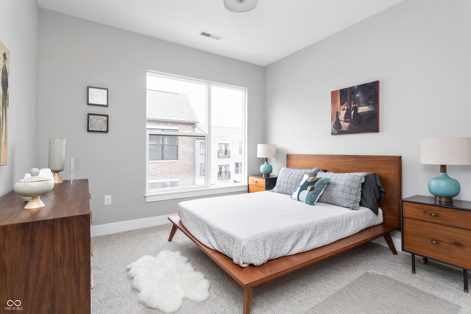 Bright primary bedroom with mid-century modern furnishings.