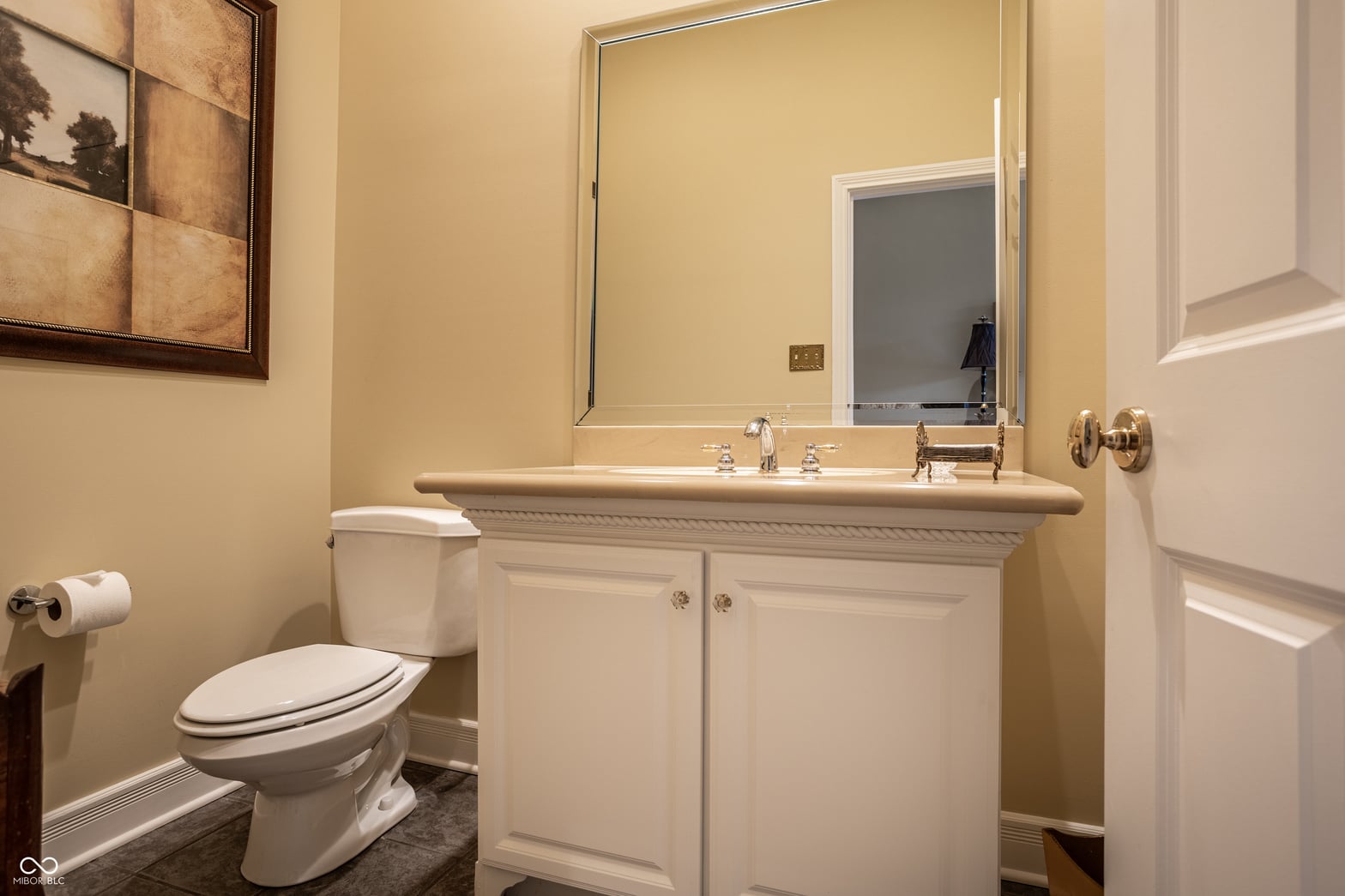 Updated primary bathroom with elegant white vanity and mirror.