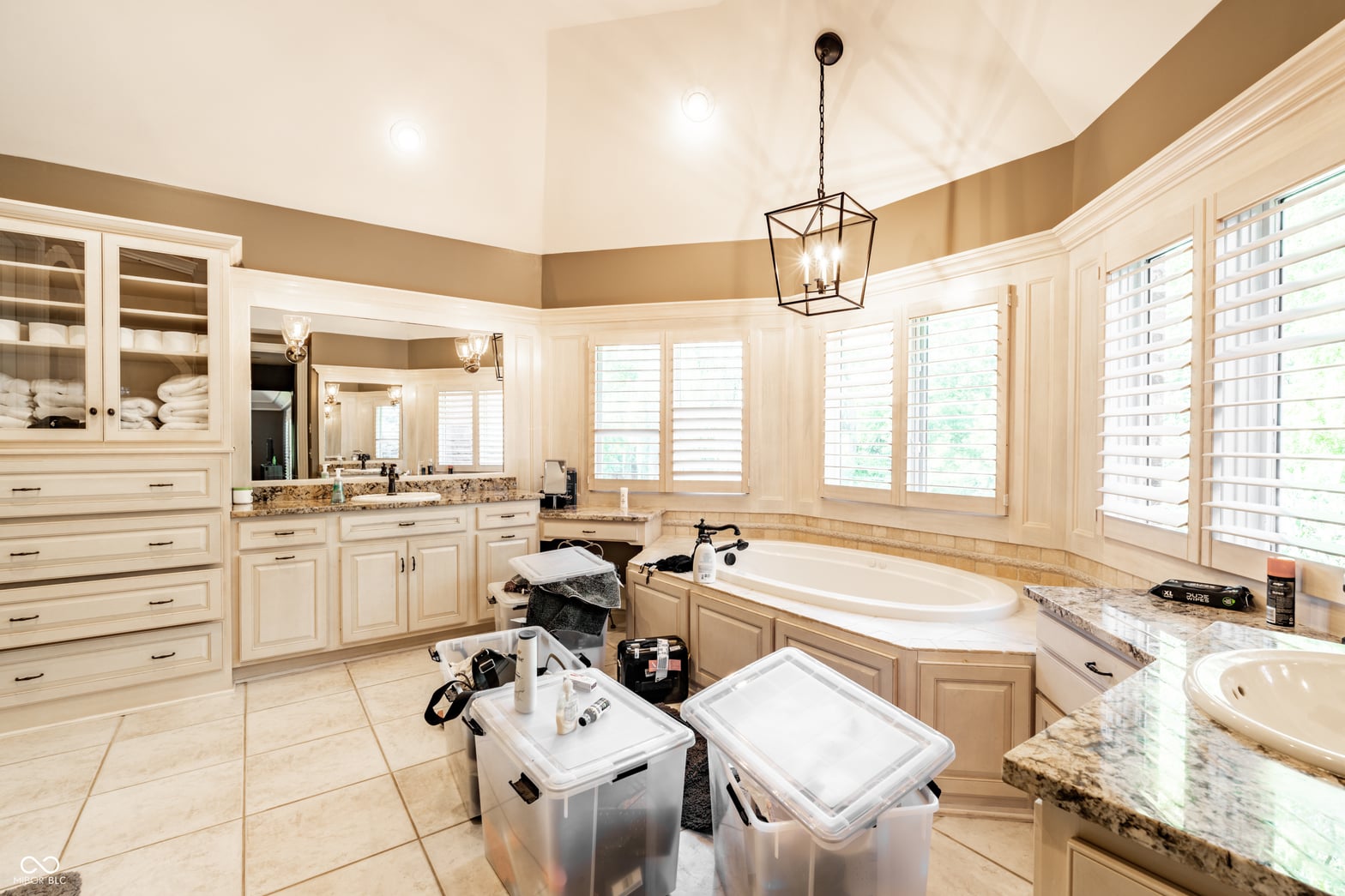 Luxurious primary bath with granite counters and natural light.