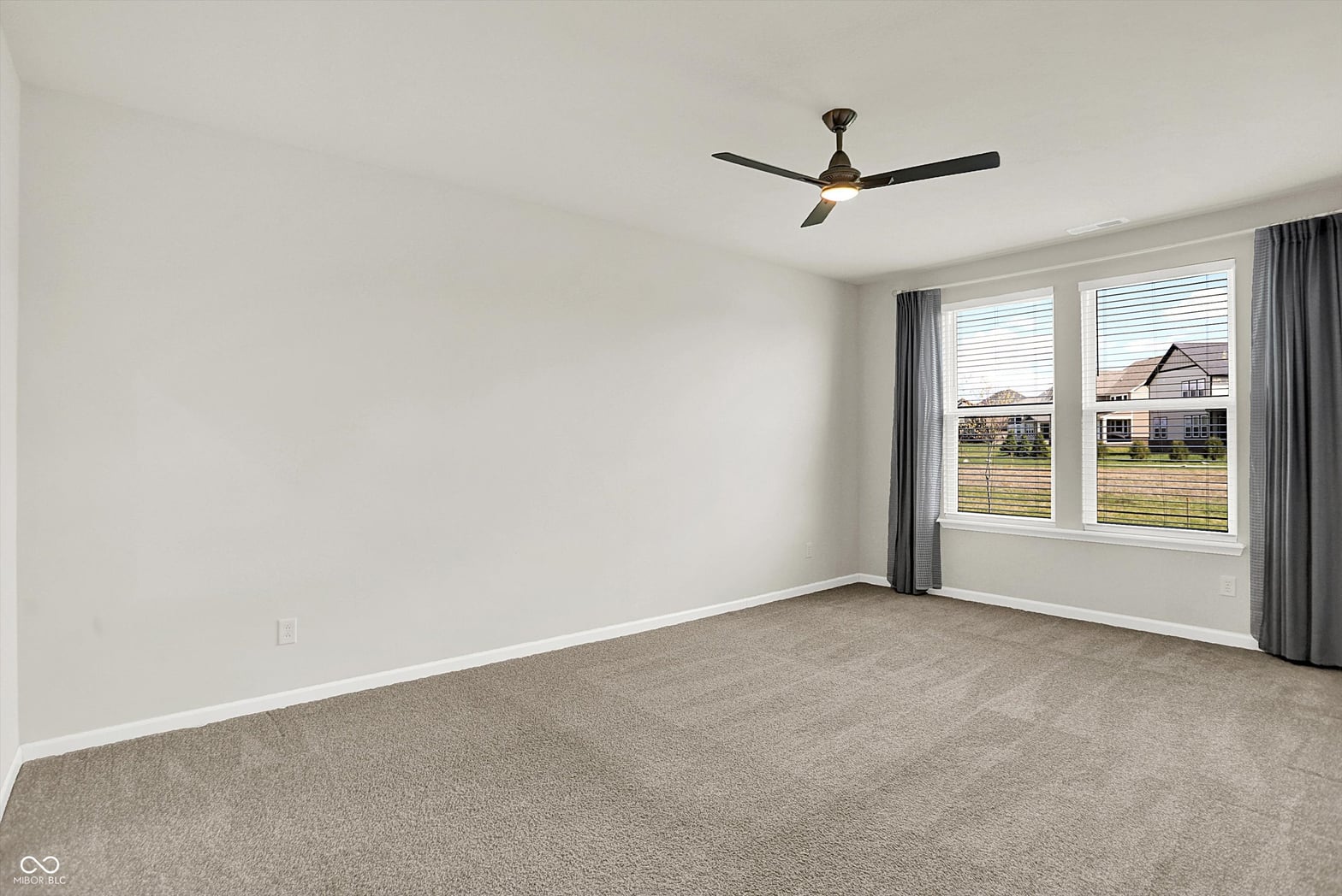Spacious bedroom with abundant natural light and windows.