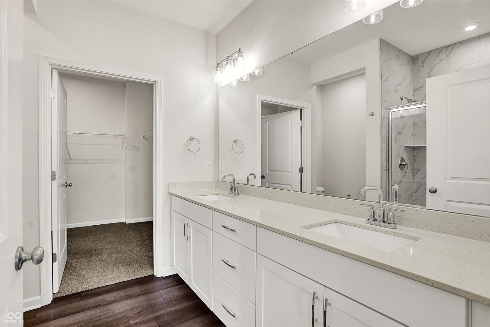 Luxurious primary bath with double vanity and marble shower.
