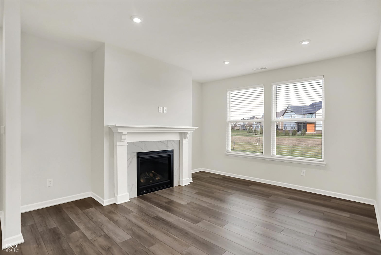 Bright living room with fireplace and hardwood floors.