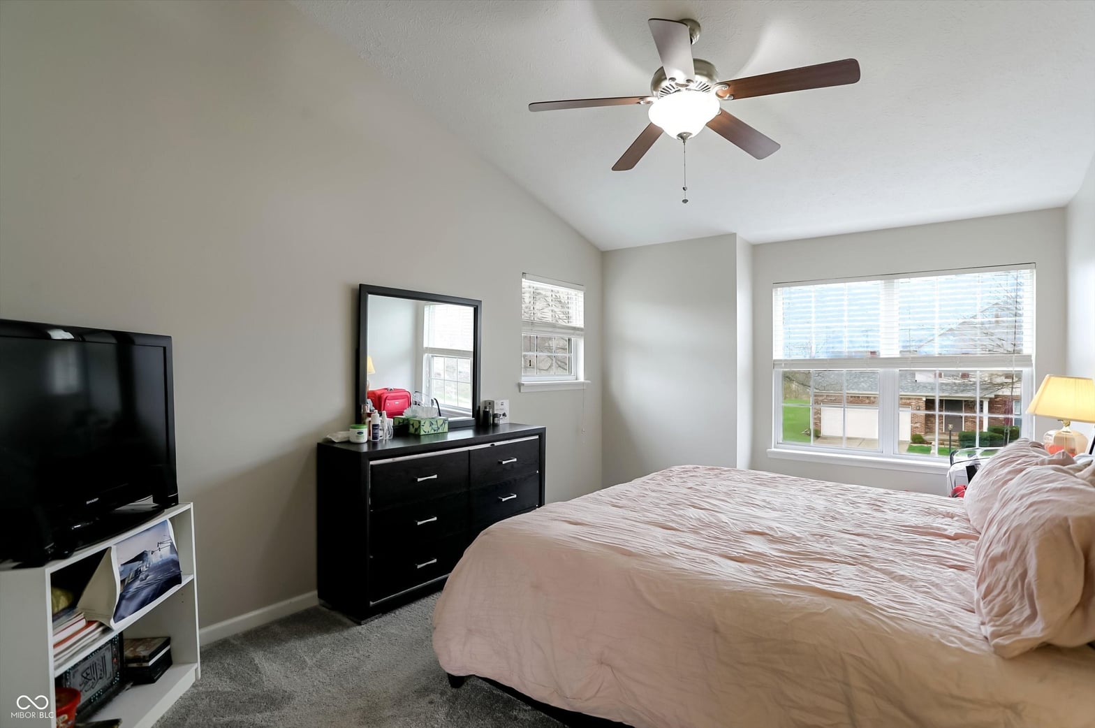 Bright primary bedroom with large windows and modern amenities.