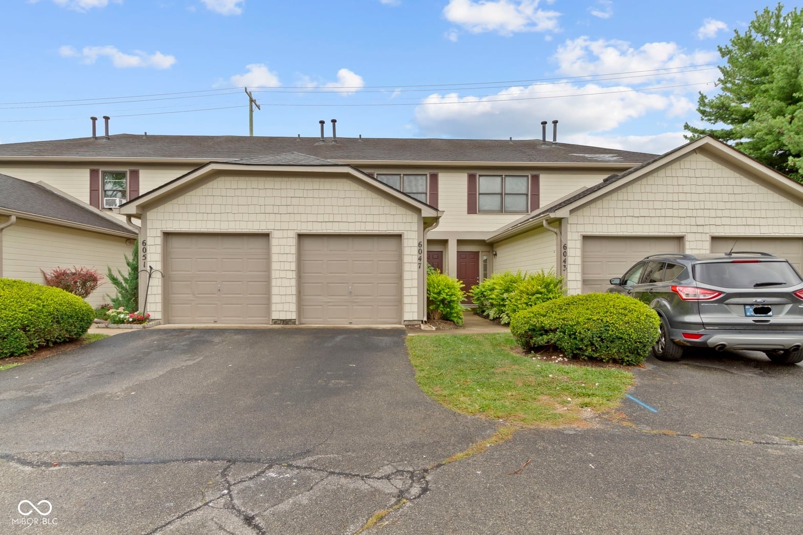 Front exterior at 6047 Southbay Drive, Indianapolis, IN — Well-maintained townhome with spacious two-car garage.