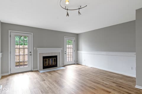 Family room at 6047 Southbay Drive, Indianapolis, IN — Bright family room with fireplace and french doors.