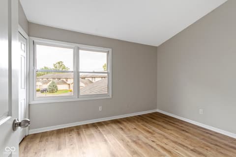 Bedroom at 6047 Southbay Drive, Indianapolis, IN — Bright bedroom with hardwood floors and dual windows.