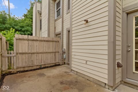 Side exterior at 6047 Southbay Drive, Indianapolis, IN — Private fenced side yard with mature landscaping.