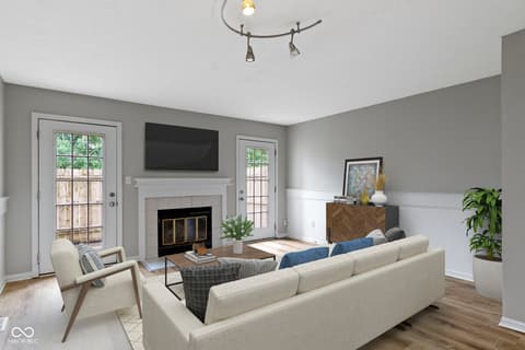 Living room at 6047 Southbay Drive, Indianapolis, IN — Bright living room with fireplace and French doors.