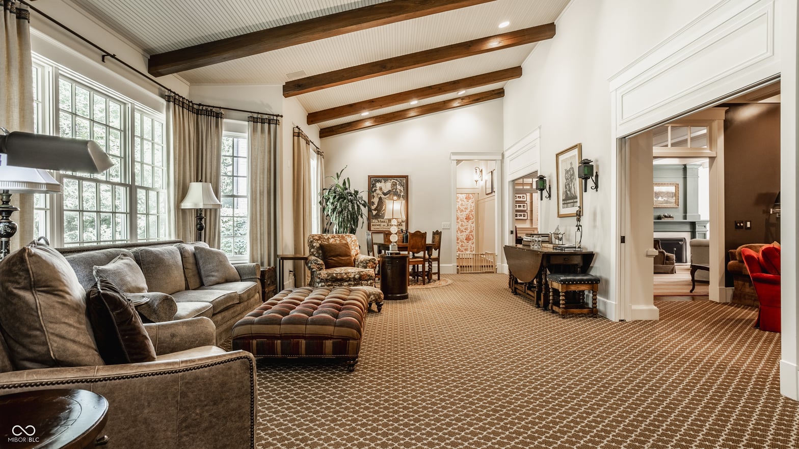 Sophisticated living room with architectural wood beams and abundant natural light.