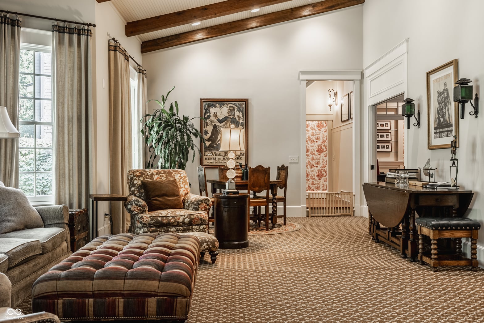 Spacious traditional family room with exposed beams and elegant furnishings.