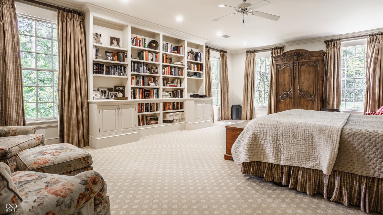 Spacious primary bedroom with custom built-in library shelving.