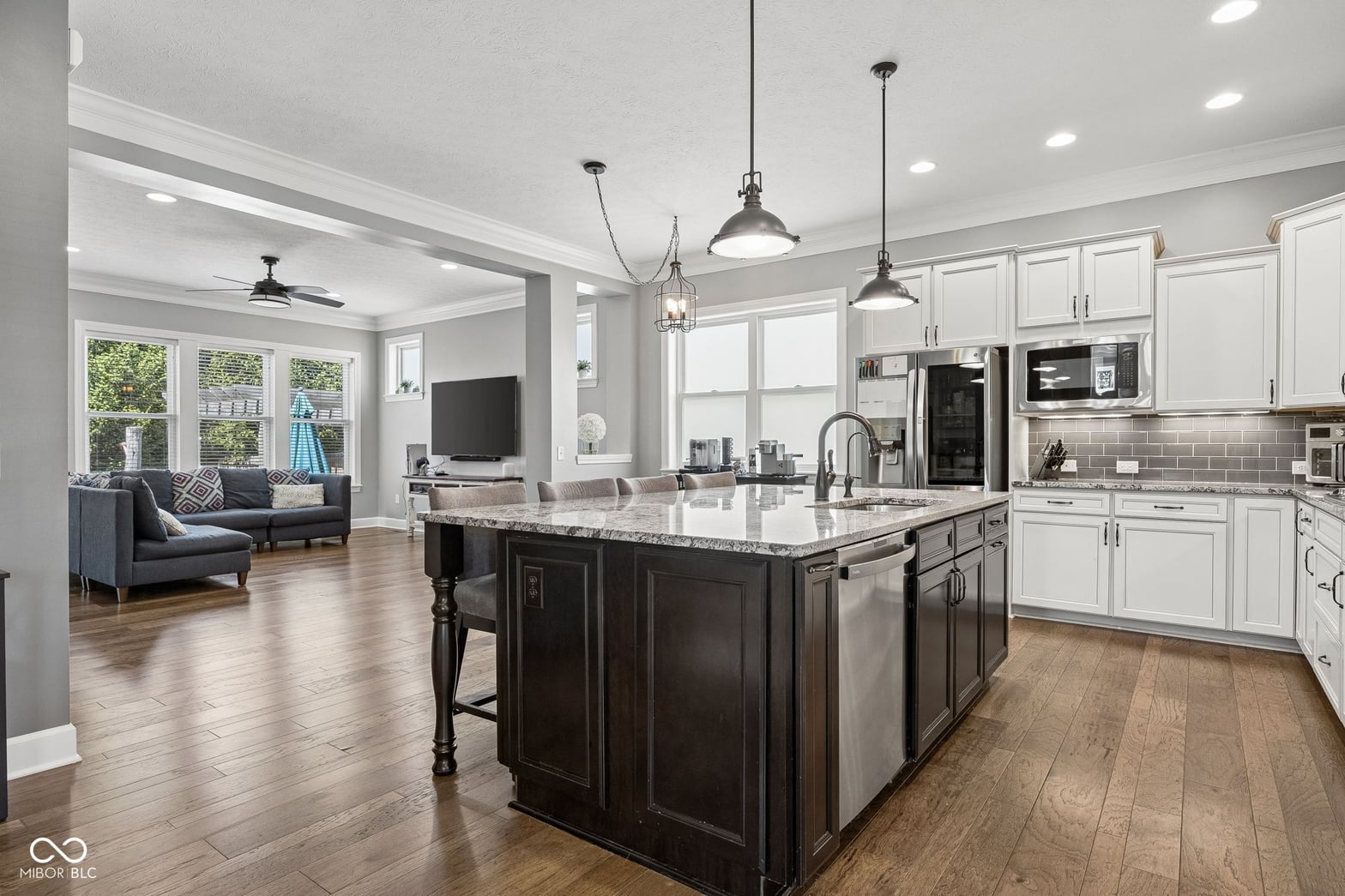 Spacious open-concept kitchen with dark island and modern lighting.