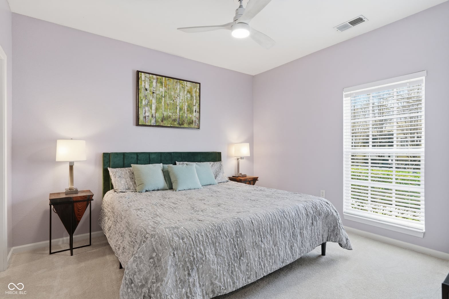 Bright primary bedroom with elegant shutters and modern updates.