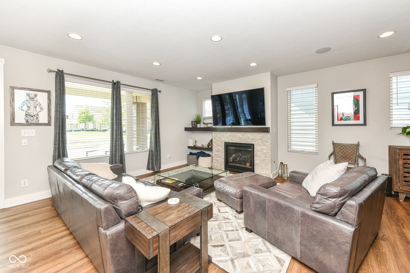 Bright contemporary living room with fireplace and abundant natural light.