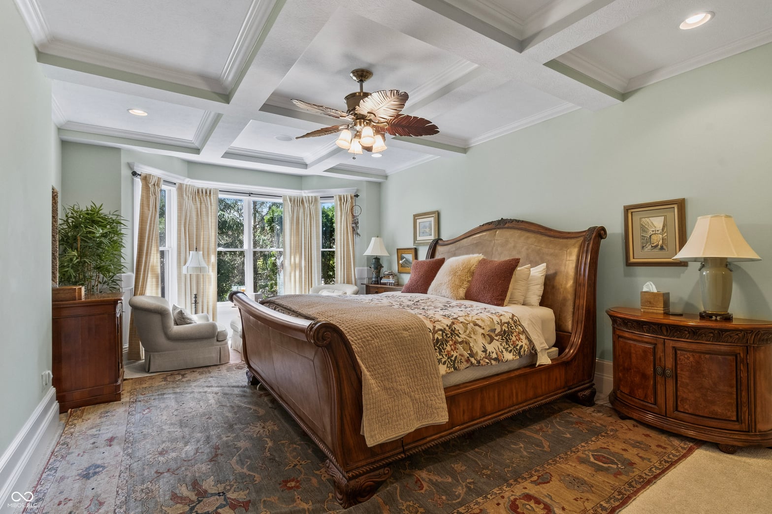 Elegant primary suite with coffered ceilings and abundant natural light.