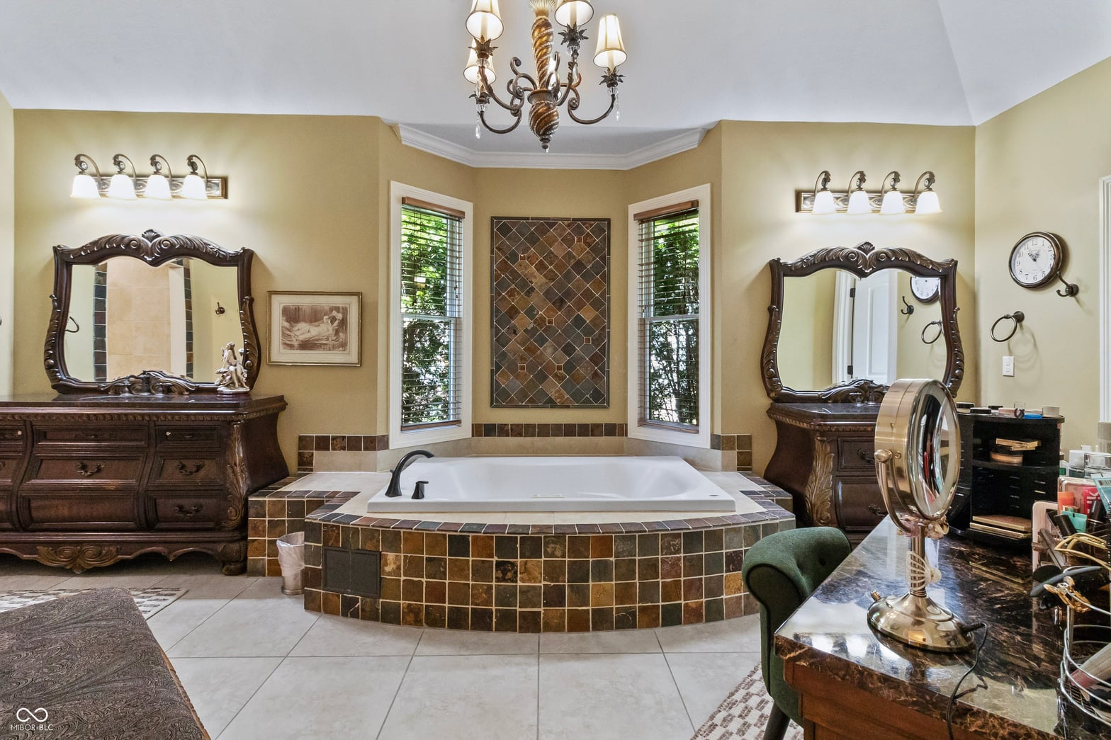 Luxurious primary bath with sunken soaking tub and dual vanities.