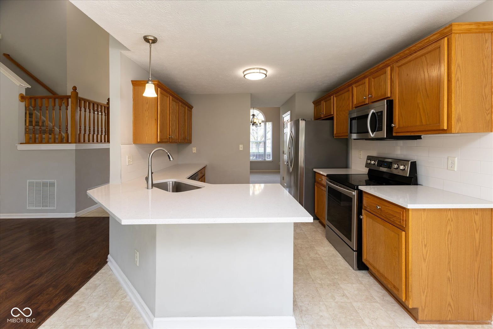 Bright updated kitchen with island and stainless steel appliances.